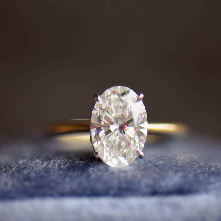 Oval diamond solitaire engagement ring with hidden halo