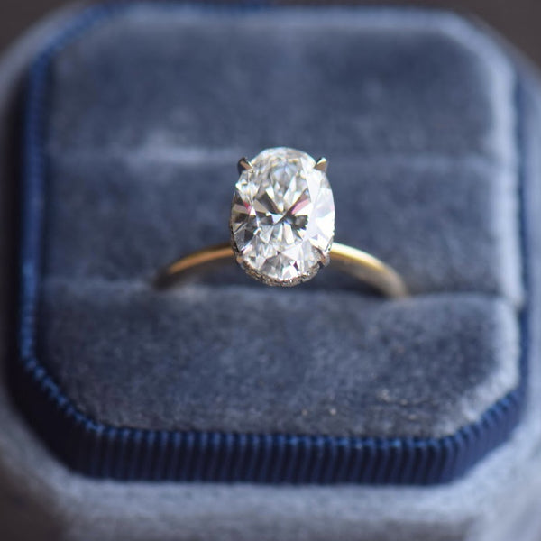 Oval diamond solitaire engagement ring with hidden halo